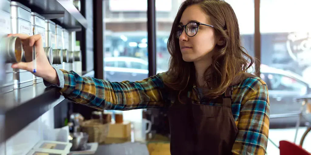 young saleswoman doing inventory in a retail store selling coffee.