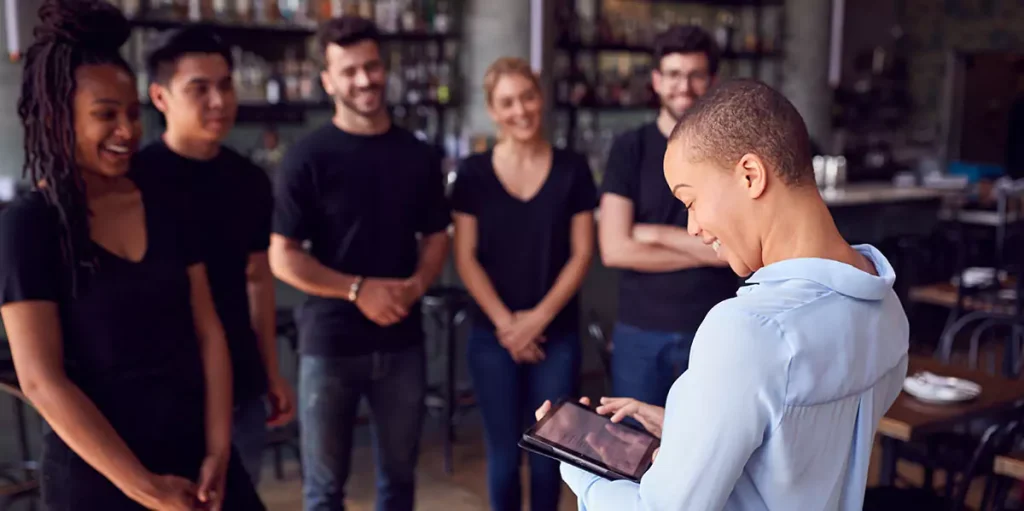 restaurant manager gathering staff for a meeting