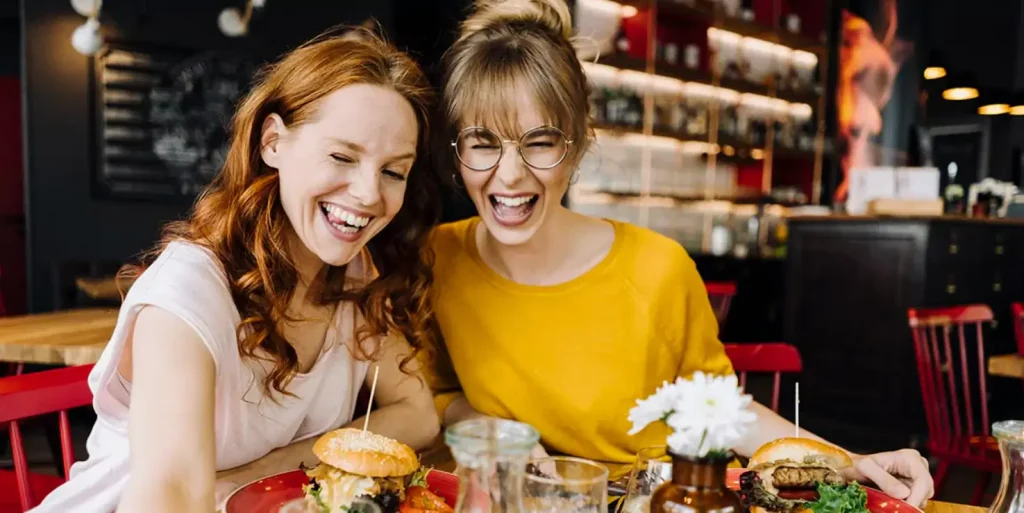 2 girls taking a selfie in a restaurant