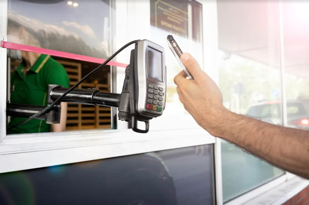 Person making drive-thru payment via phone