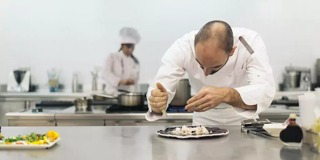 Male professional chef cooking in a kitchen.