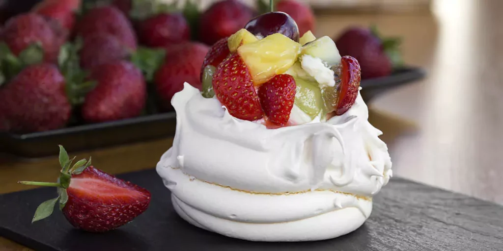 Restaurant dessert - Anna Pavlova meringue with low-fat whipped cream and fresh strawberry