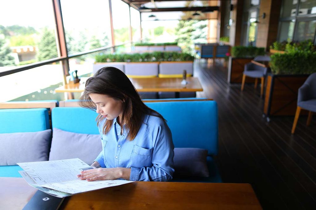 Analyzing Your Menu Items’ Profitability With Restaurant Business Intelligence - customer reading a menu