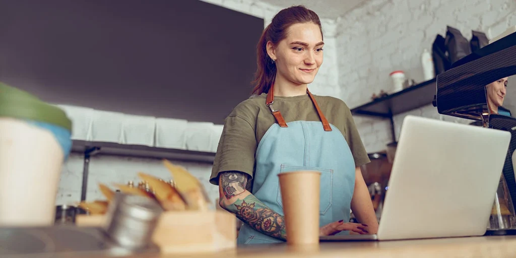 female cafe worker using a laptop